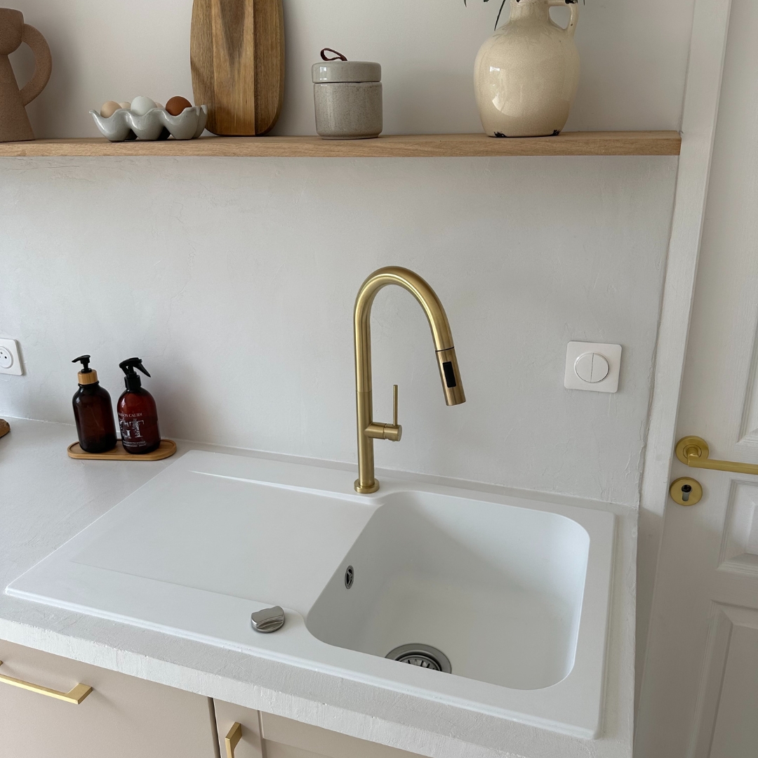 Cette cuisine pensée et réalisée par at:marinegaby_ est la parfaite définition du design et de la sobriété !   Le plan de travail est large et épuré, et les couleurs pastel nous envoutent totalement 🥰  Le mitigeur or brossé associé à l'évier blanc crée un jeu de contraste subtil avec les meubles rose pastel 🩷 On adore chaque élément de la cuisine, des poignées dorées aux accessoires !  Le + de ce plan de travail : l'évier avec égouttoir dont la couleur blanche lui permet de se fondre complètement dans le décor et qui fait ressortir le mitigeur ✨  On ne peut que vous inciter à vous inspirer de cette superbe décoration pour votre rénovation de cuisine 🫶  #democratikdesign #essebagno #évier #decocuisine #decohome #mitigeur #decohome #kitchendecor #homedecor #renovationmaison #renovationcuisine