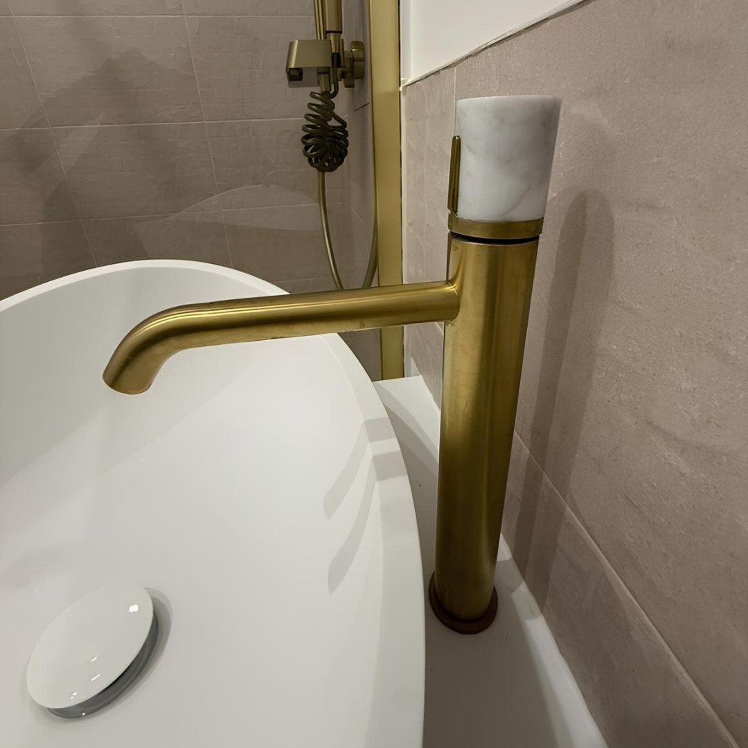 Simplicité et luminosité, tels sont les mots utilisés pour décrire cette salle de bain 🤍  Les finitions dorées de l'or brossé et du blanc offrent un résultat lumineux et plein de caractère ✨  Notre mitigeur de lavabo et la colonne de douche finition or brossé apportent une touche de chic et focalisent la lumière !  Merci à at:originatelier de si bien mettre en avant nos produits 🥰  #essebagno #democratikdesign #robinetterie #bathroomdesign #salledebain #douches #faucet