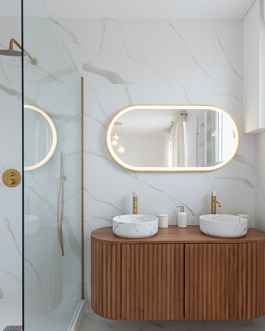 Quand le marbre, le bois et l’or brossé se rencontrent, la salle de bain devient une vraie pièce de caractère 🎊  Le marbre blanc apporte de la lumière, tandis que le meuble en bois réchauffe l’ensemble avec une touche très contemporaine 🤍  Au centre de cette composition, nos mitigeurs de lavabo Manopola en or brossé viennent capter la lumière et sublimer les vasques effet marbre ✨  On aime aussi le rappel du doré dans la robinetterie de douche et le miroir rétroéclairé qui agrandit visuellement l’espace ! ☀️  Un équilibre parfait entre matières naturelles, lignes douces et finitions élégantes pour une salle de bain aussi design qu’apaisante 🥰  Merci à at:originatelier de nous avoir identifiés sur sa superbe réalisation 🙏   #democratikdesign #essebagno #mitigeur #salledebain #bathroomdesign #bathroomdecor #decointerieur #renovationmaison #homedecor